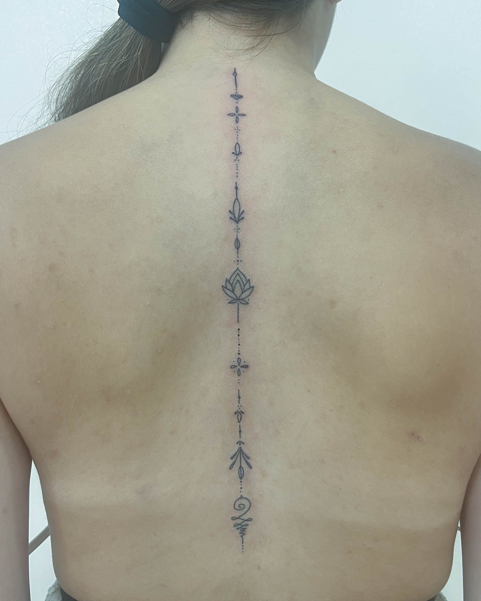 fine line ornamental vertical line tattoo minimalist valencia