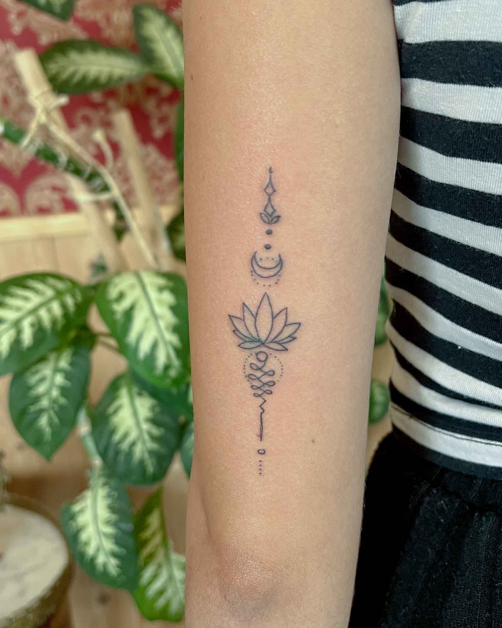 tatuaje símbolo ornamental vertical línea fina con luna y loto