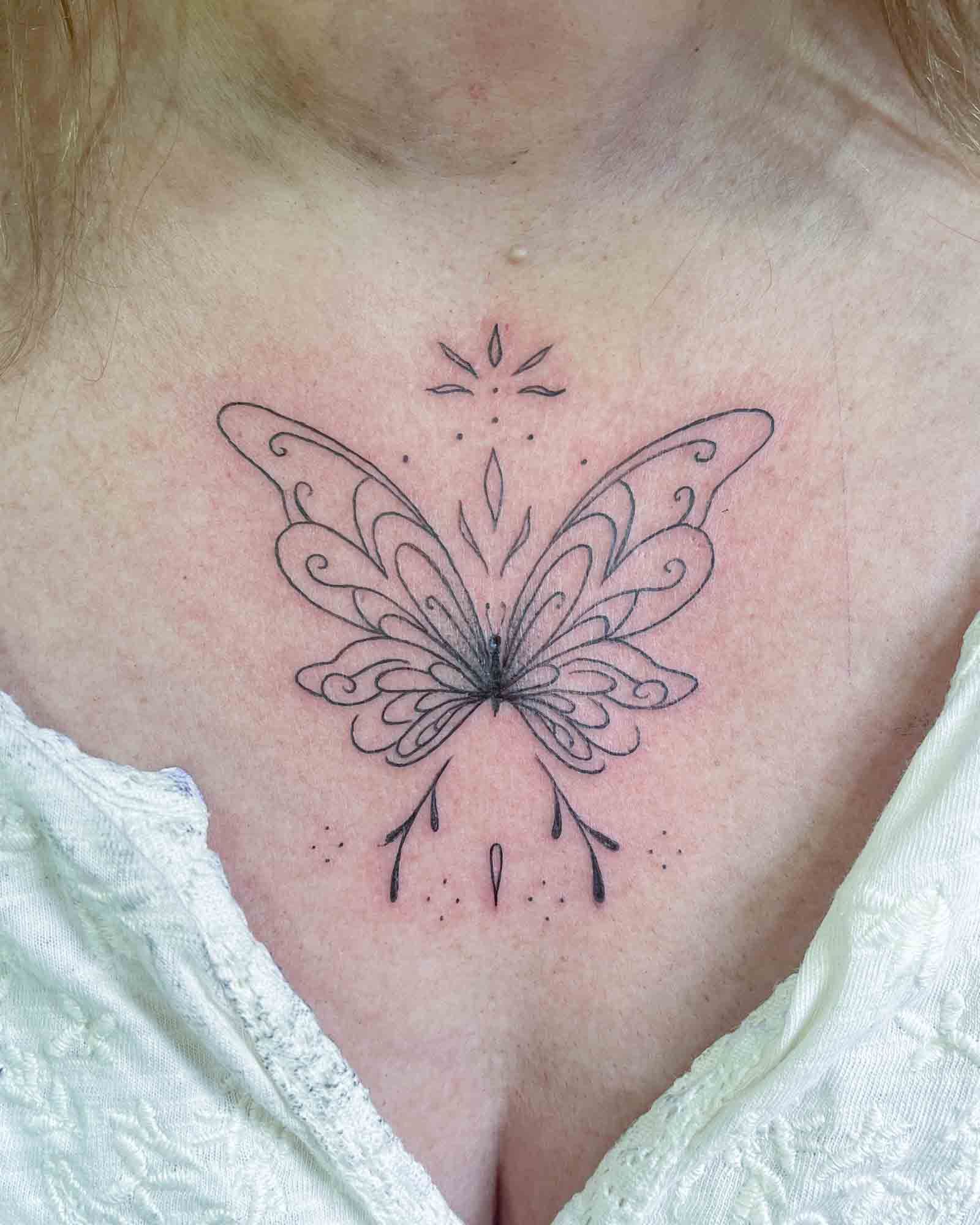 tatuaje linea fina mariposa ornamental pecho valencia