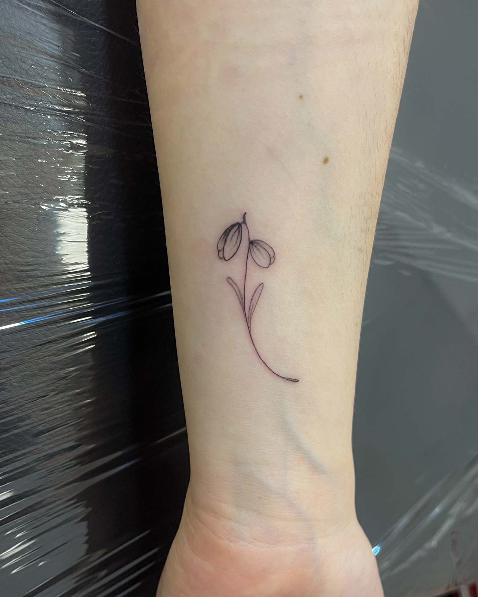 fine line tulip tattoo small wrist valencia